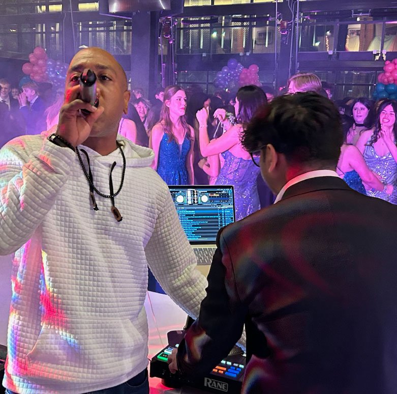 Professional DJ and MC engaging guests at a corporate or wedding event with high-energy music and professional hosting